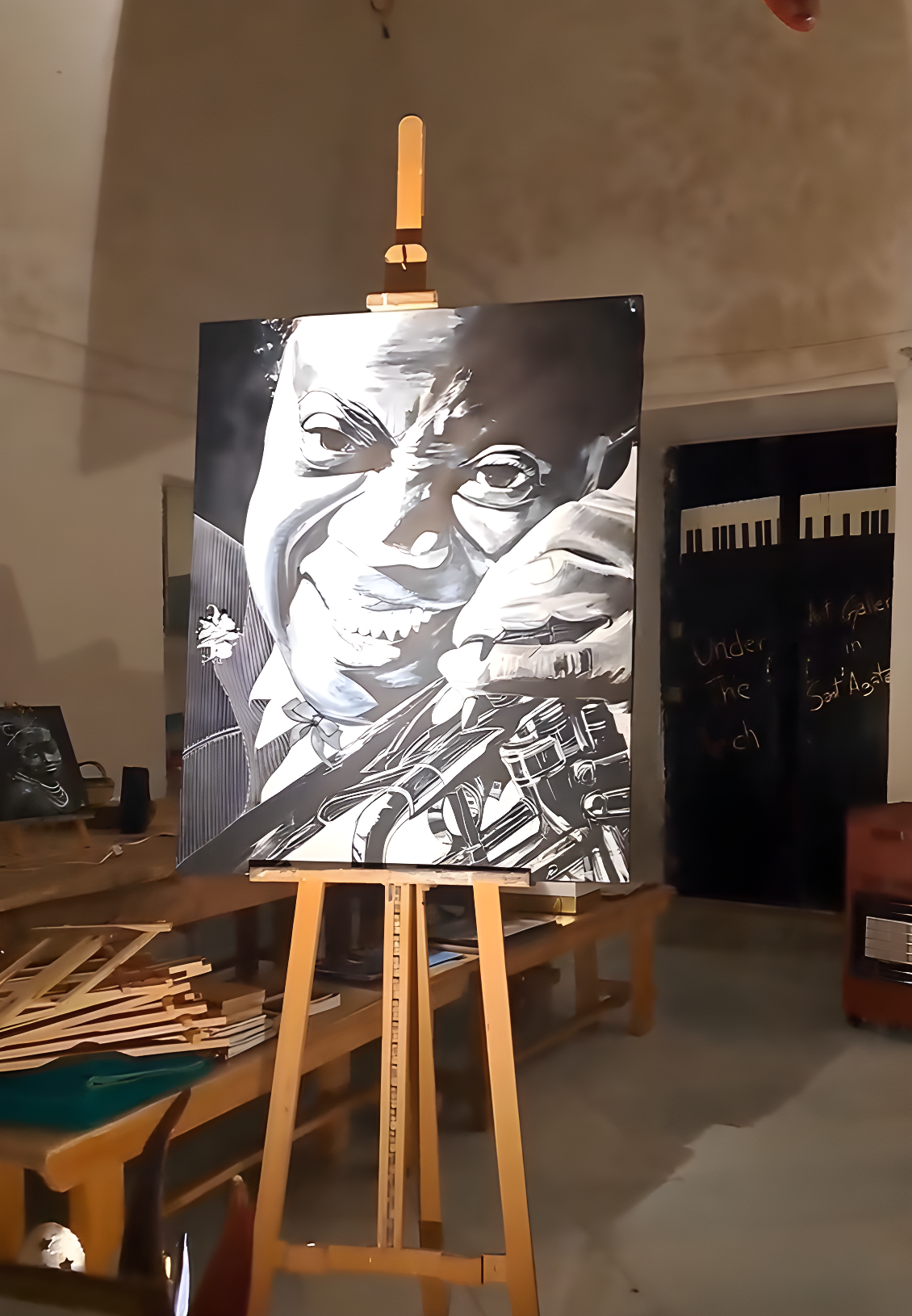 A striking black and white acrylic portrait of a jazz musician on an easel inside Under the Arch Art Gallery.
